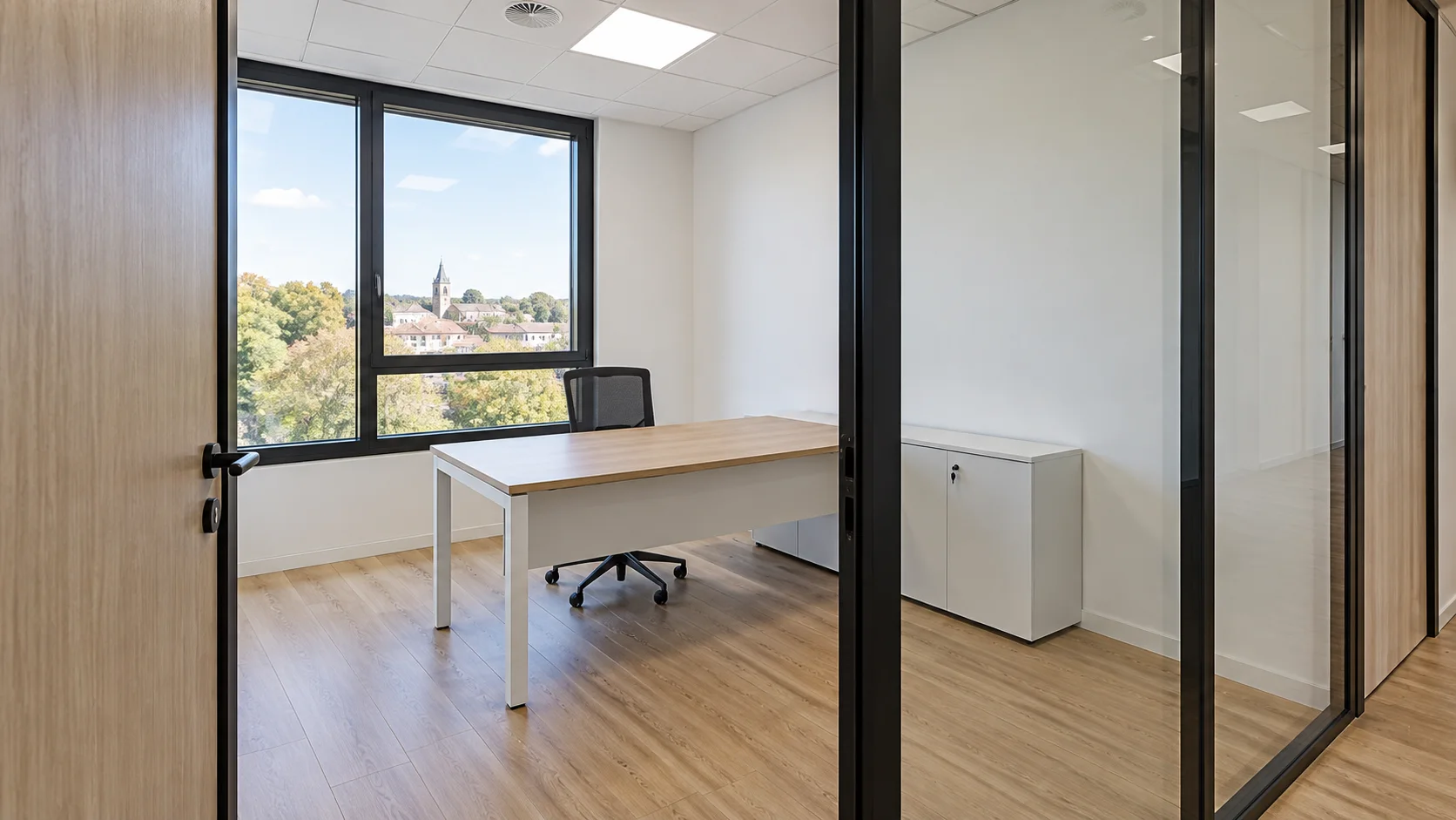 Bureau individuel fermé par une cloison vitrée, parquet chêne et vue sur la ville