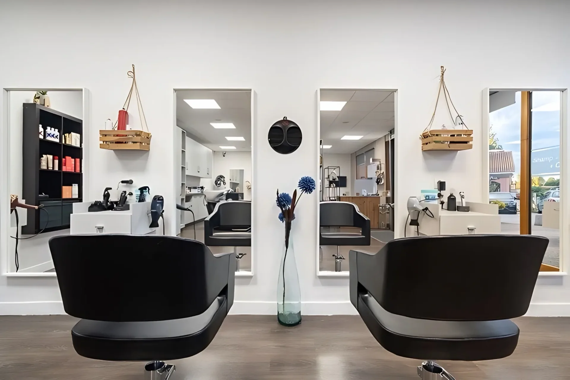 Postes de coupe alignés devant leurs miroirs dans un salon de coiffure aménagé, agencement de commerce