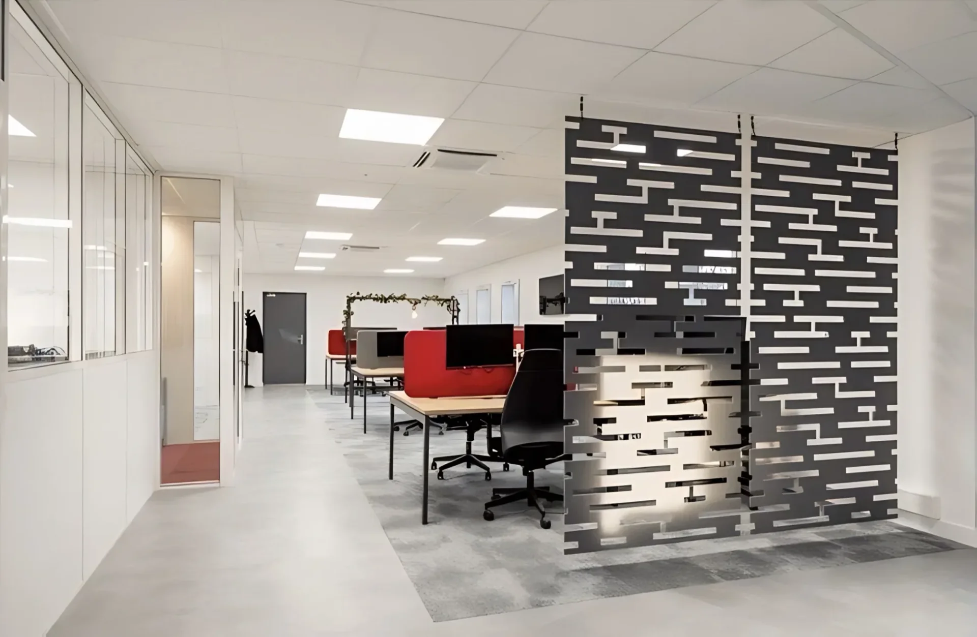Claustra ajouré noir séparant les zones d’un open space, aménagement de bureaux