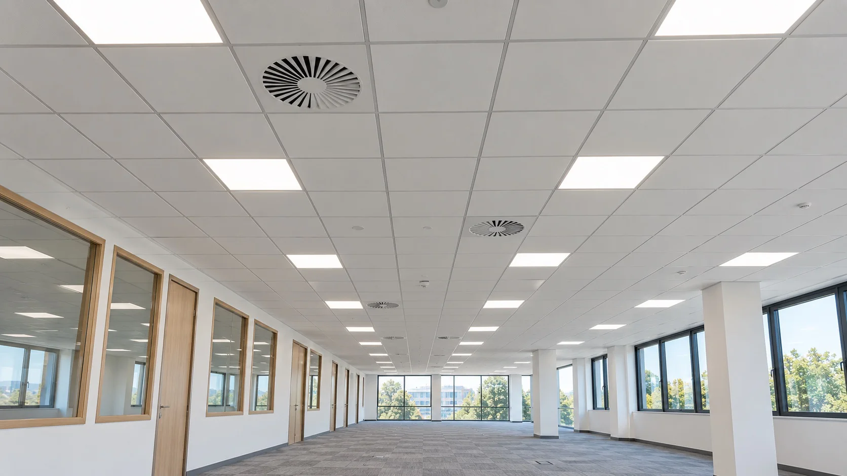 Plateau de bureaux vide sous un faux plafond à dalles blanches intégrant dalles lumineuses et diffuseurs de ventilation, ECM à Vienne, Bourgoin-Jallieu et Lyon