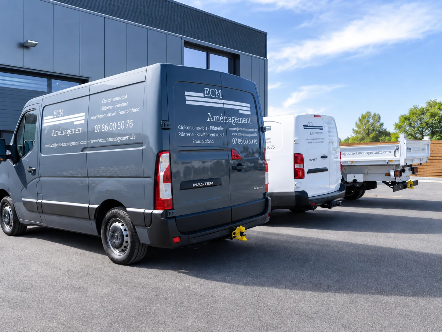 Trois véhicules utilitaires floqués ECM Aménagement stationnés devant le dépôt de l’entreprise